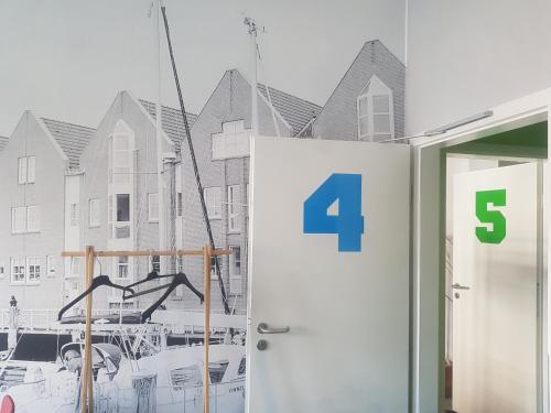 a door with the number four next to a building at Sleeptide in Husum