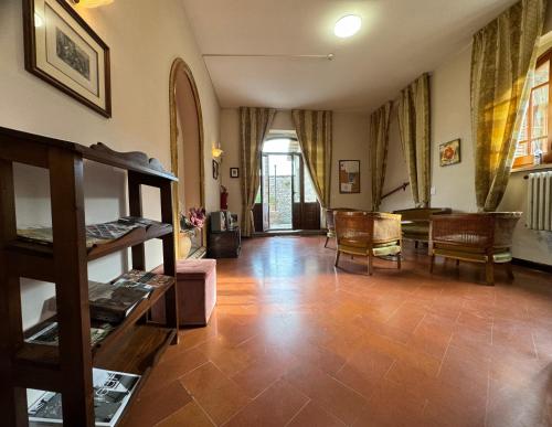 a living room with wooden floors and a room with chairs at Monastero SS. Annunziata in Todi