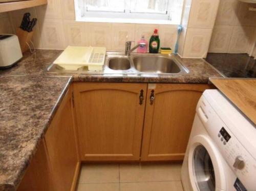 a kitchen with a sink and a washing machine at White City private room in London