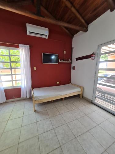 a room with a bench and a tv on a wall at LAS MARIAS - CHAJARI in Chajarí