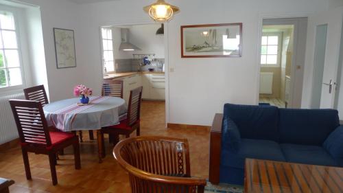 un salon avec une table et un canapé bleu dans l'établissement Appartement vue sur mer, à Bénodet