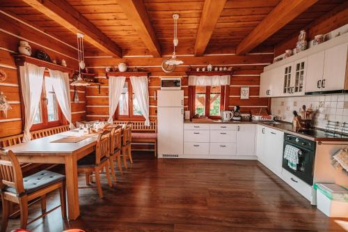 a kitchen with a table and chairs in a cabin at Chalupa U Ceďora in Petrovičky