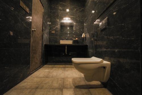 a black bathroom with a toilet and a sink at AGP Nature Villa in Udaipur