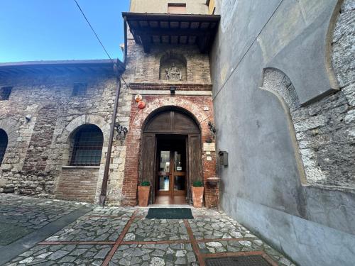 un vecchio edificio in mattoni con una porta e un muro di pietra di Monastero SS. Annunziata a Todi