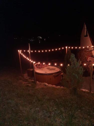 a lit up hot tub in a yard at night at Cabana Busuioc in Colibiţa