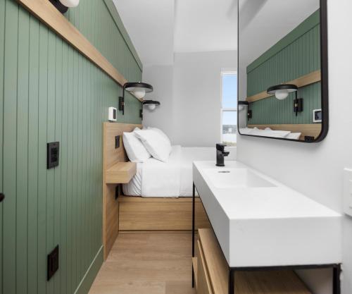 a bathroom with a bed and a sink and a mirror at Riverside Tower Hotel in New York