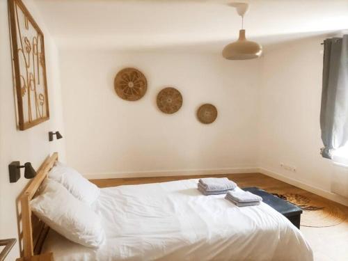 una camera da letto con un letto bianco con due asciugamani di Maison de ville avec jardin, proche vignoble a Courthézon