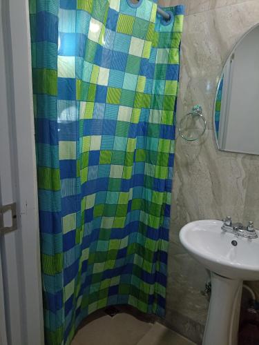 a bathroom with a shower curtain and a sink at DaDaJuBa Aparta hotel in Santa Bárbara de Samaná