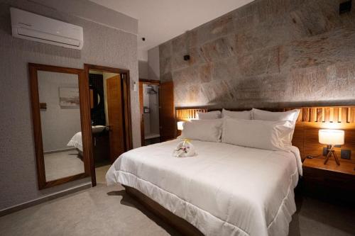 una camera da letto con un grande letto bianco e uno specchio di Sophie Hotel Boutique a Santa Cruz Huatulco