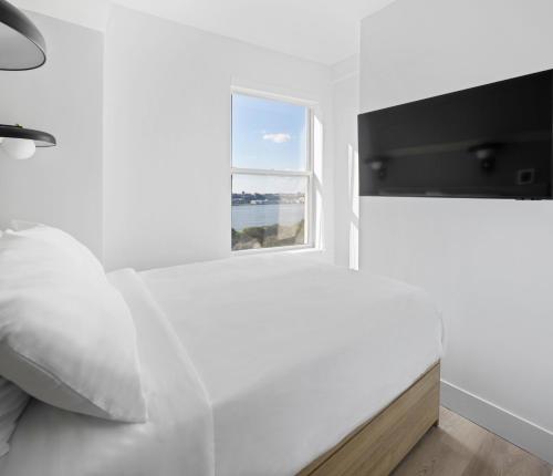 a bedroom with a white bed and a window at Riverside Tower Hotel in New York