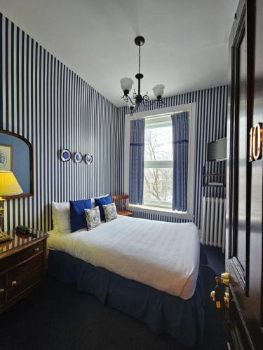a bedroom with a bed and a window at Manoir Sherbrooke in Montréal