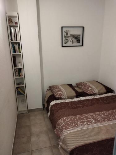 une chambre avec deux lits et une étagère dans l'établissement Sanary sur Mer Appartement 30m2 T2 avec terrasse Piscine 10min à pied de la plage, à Sanary-sur-Mer