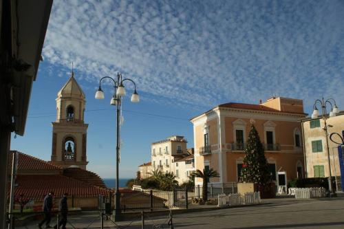 um grupo de edifícios com uma árvore de Natal e uma igreja em Bellezza In Cilento Panoramic Apts em Castellabate
