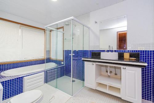 a bathroom with a shower and a toilet and a sink at Chacara da Dinda in Piraquara