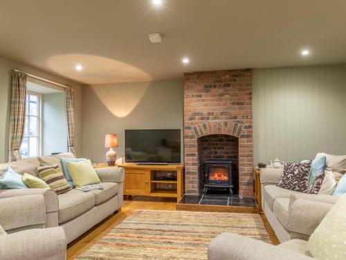 a living room with two couches and a fireplace at 3 bed property in Axminster BLOCO in Axminster