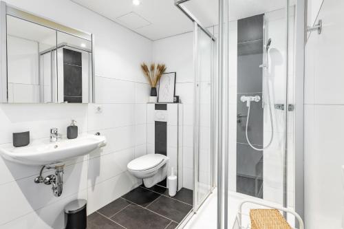 a white bathroom with a toilet and a shower at City Apartment DOWNTOWN in Bregenz