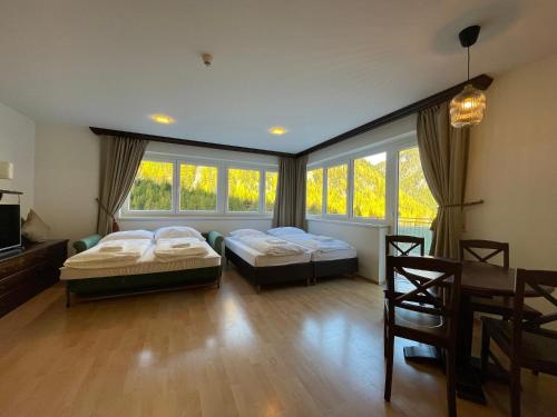 two beds in a room with windows at International House Sölden Studio mit Balkon ZW 2 in Sölden