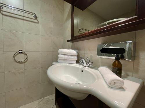 a bathroom with a sink and a mirror and towels at International House Sölden Studio ZW 3 in Sölden