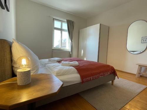 - une chambre avec un lit, une table et un miroir dans l'établissement Studio im Zentrum von Lochau, #4, à Lochau