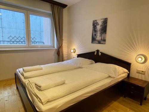 International House Sölden Standard Apartment ZW 10 في سولدن: سرير في غرفة نوم مع نافذة كبيرة
