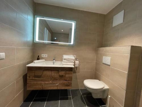 bagno con lavandino, servizi igienici e specchio di International House Sölden Apartment mit 3 Schlafzimmern ZW AP 6 a Sölden