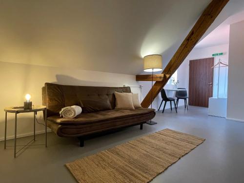 - un salon avec un canapé brun et une table dans l'établissement Studio im Zentrum von Lochau, #3, à Lochau
