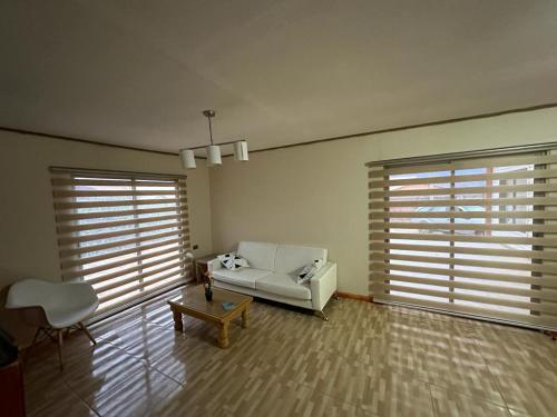 a living room with a white couch and two large windows at Casa En Papudo Lomas del Mar in Papudo