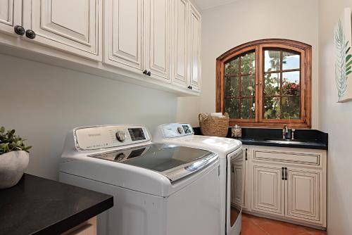 cocina con lavadora y fregadero en Rooftop Oceanview Patio - 5BR Remodeled Home, en Carlsbad