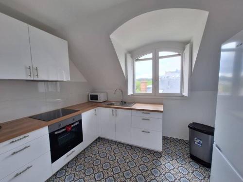 une cuisine blanche avec un évier et une fenêtre dans l'établissement Le Voluptueux - Au cœur de Versailles - 343B, à Versailles