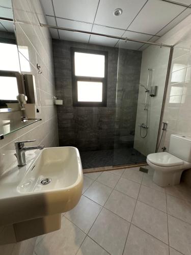 a bathroom with a sink and a shower and a toilet at Al Dana Sea View Villa in Fujairah