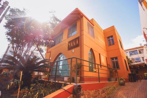 a orange building with the sun shining on it at Poente Hostel in Belo Horizonte