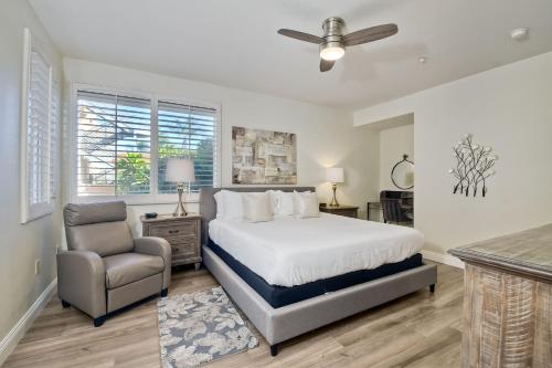 a bedroom with a bed and a chair at Lagoon Views - Pool - Hot Tub - Gated Community in Carlsbad
