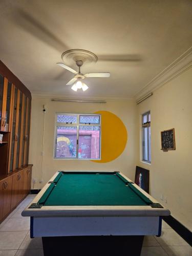 a pool table in a living room with a ceiling at Poente Hostel in Belo Horizonte