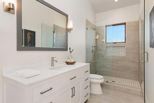 y baño blanco con lavabo y ducha. en Oceanview Rooftop Patio - Walk To The Beach & Park en Carlsbad