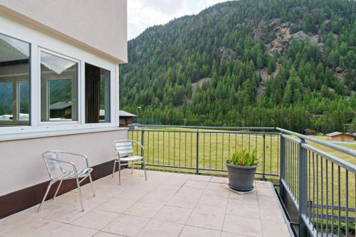 een balkon met 2 stoelen en uitzicht op een berg bij International House Sölden Studio mit Bergblick ZW 1 in Sölden