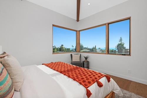 a bedroom with a bed and large windows at Oceanview Rooftop Patio - Walk To The Beach & Park in Carlsbad