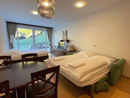 a bedroom with a bed and a table and a dining room at International House Sölden Studio ZW 5 in Sölden