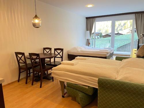 a hospital room with two beds and a table and chairs at International House Sölden Studio-Apartment ZW 6 in Sölden