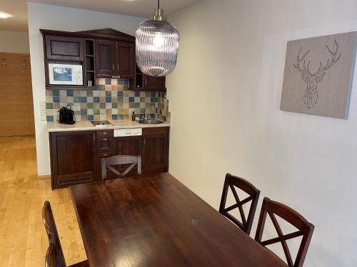 eine Küche mit einem Holztisch und einem Esszimmer in der Unterkunft International House Sölden Deluxe Apartment ZW 13 in Sölden