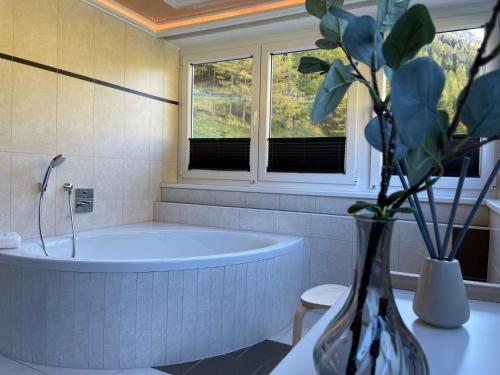 un bagno con vasca e vaso con una pianta di International House Sölden Superior Suit Penthouse a Sölden