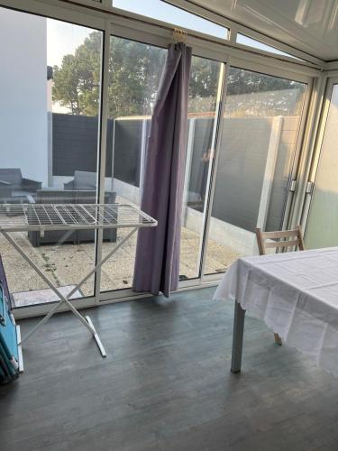 um quarto com uma mesa e algumas janelas de vidro em le Rocher em La Plaine-sur-Mer