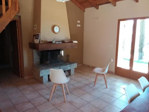 salon z kominkiem i białymi krzesłami w obiekcie Casa Jeromine w mieście Quenza