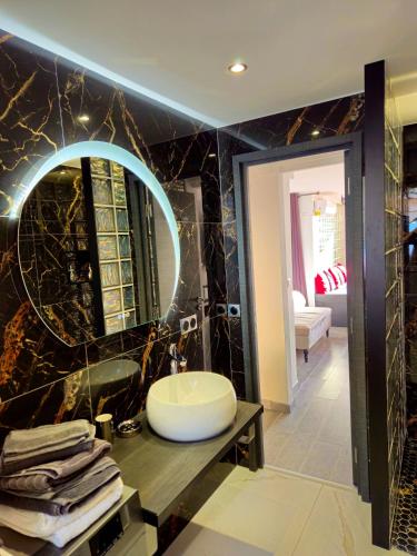 a bathroom with a sink and a large mirror at DAJO in Cap d'Ail