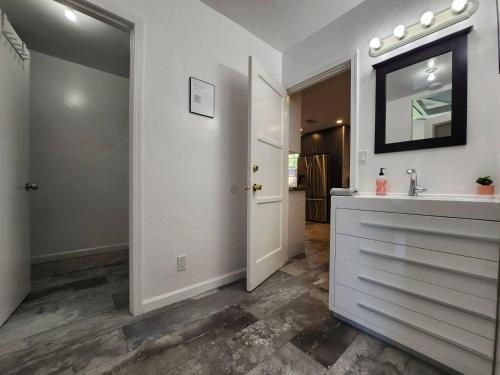 uma casa de banho branca com um lavatório e um espelho em Guest Quarters Torrey Pines Golf Ucsd Salk Scripps em San Diego