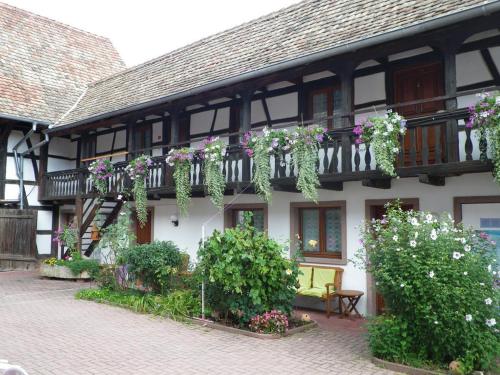 een gebouw met bloemen aan de zijkant bij A l'arc en ciel in Blaesheim