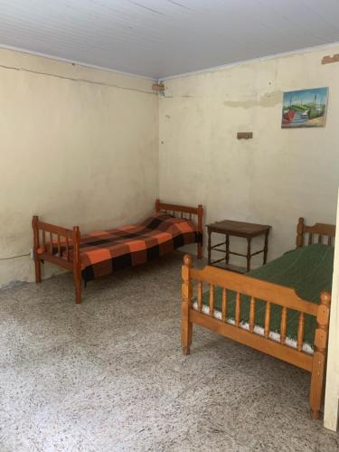 a room with two beds and two tables at Aldeia Gaia Chalés in Teresópolis