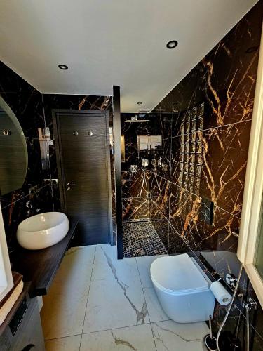 a bathroom with a sink and a toilet and a shower at DAJO in Cap d'Ail