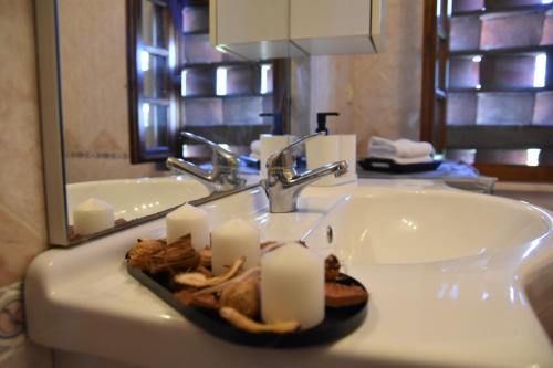 a bathroom sink with candles on it with a mirror at appartamento vacanze Sofia house in Capannori