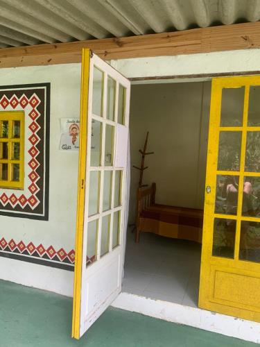 una puerta abierta a una habitación con sofá en Aldeia Gaia Chalés en Teresópolis