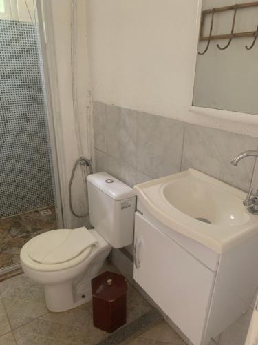 a white bathroom with a toilet and a sink at Aldeia Gaia Chalés in Teresópolis